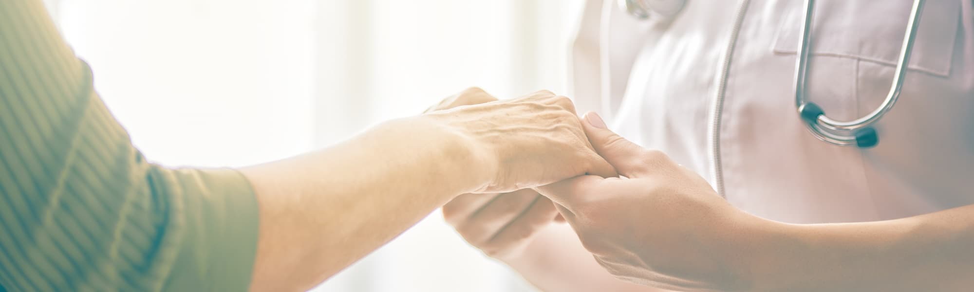 Ein Arzt / eine Ärztin hält einen Patienten an der Hand. Ein Gichtanfall ist äußert schmerzhaft für die Betroffenen. Eine wirksame und schnelle Behandlung ist wichtig. 
